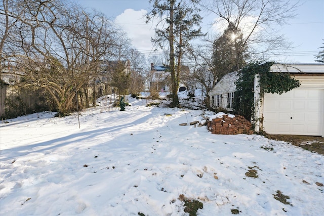 snowy yard featuring a garage