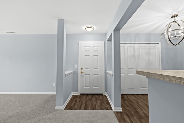 entryway featuring dark wood-type flooring and a notable chandelier