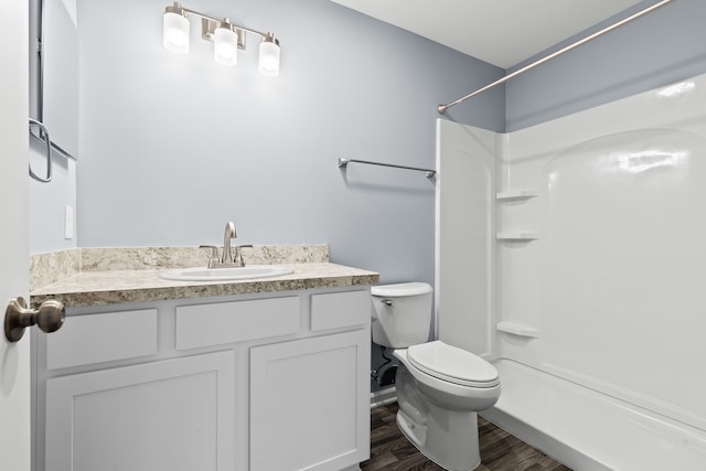 bathroom with vanity, toilet, wood-type flooring, and a shower