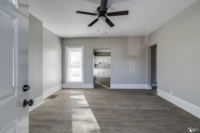 spare room featuring dark wood-type flooring and ceiling fan