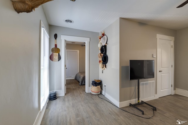 corridor with hardwood / wood-style flooring