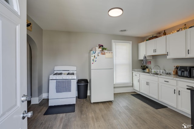 kitchen featuring white cabinetry, sink, white appliances, and light hardwood / wood-style flooring