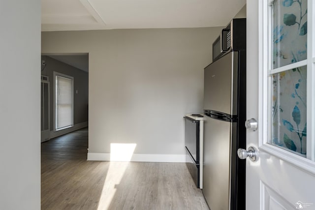 interior space featuring range with electric cooktop, light wood-type flooring, and stainless steel refrigerator