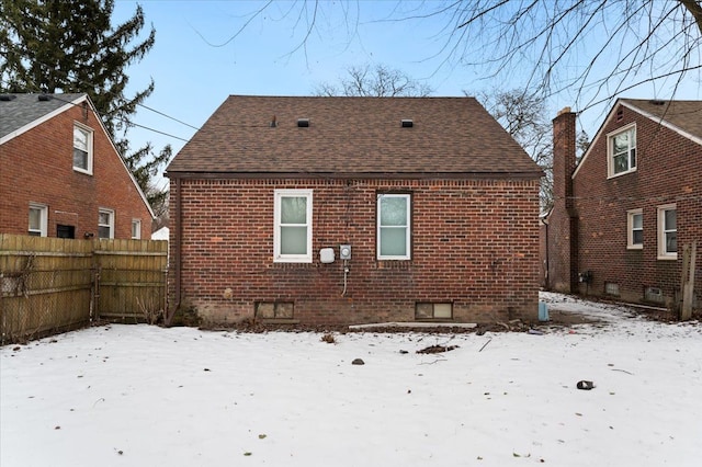 view of snow covered back of property