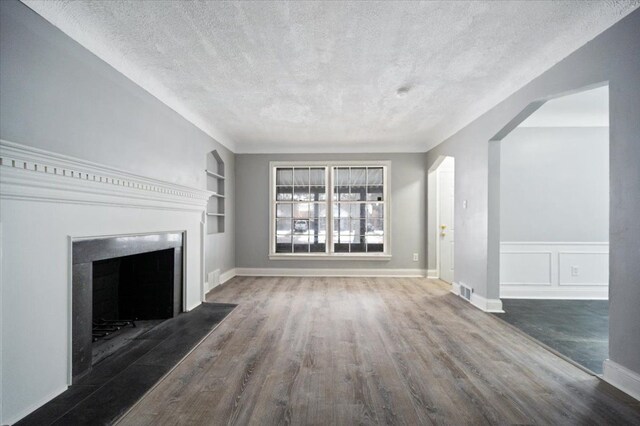 unfurnished living room with dark hardwood / wood-style flooring, built in features, and a textured ceiling