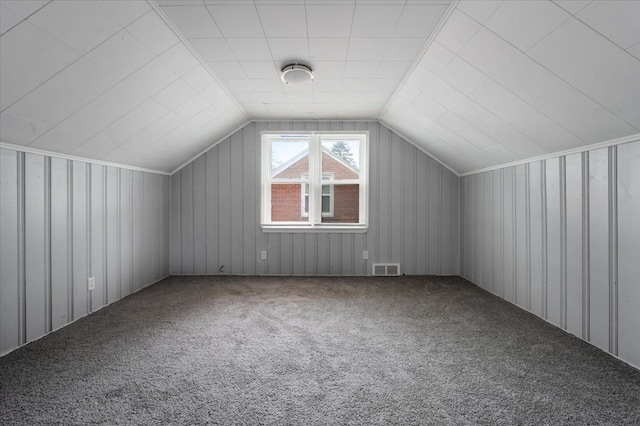 bonus room featuring vaulted ceiling and carpet