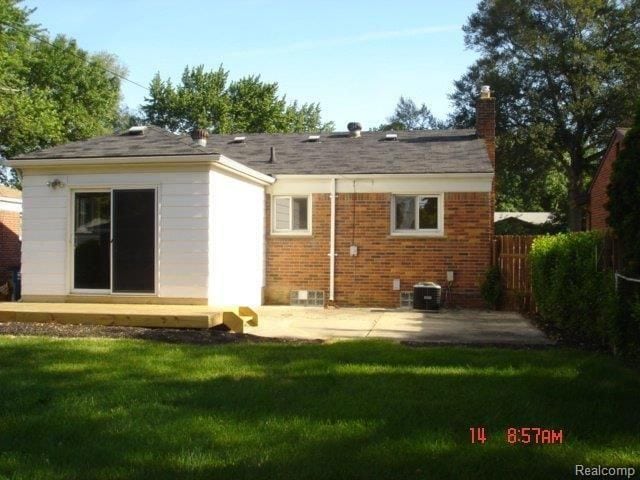 back of house with a patio, a yard, and central air condition unit