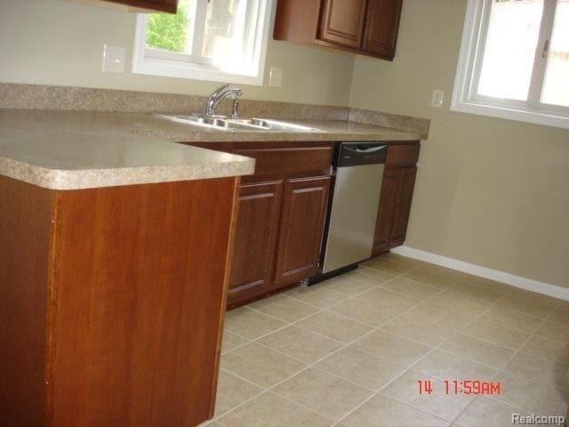 kitchen with sink, light tile patterned floors, and dishwasher