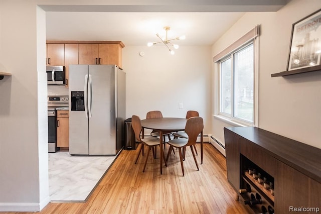 dining room with a baseboard heating unit, a chandelier, and light wood-type flooring