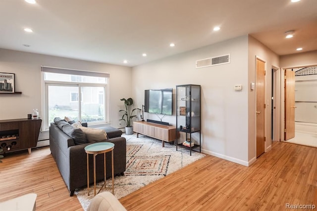 living room with a baseboard radiator and light wood-type flooring