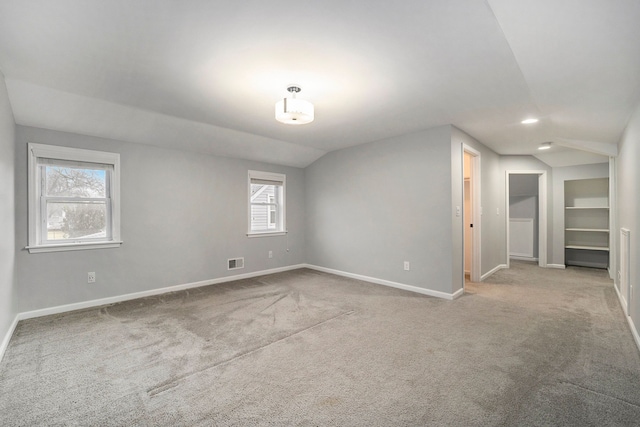 spare room with lofted ceiling and light carpet