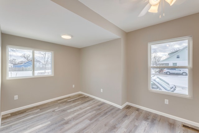 empty room with ceiling fan and light hardwood / wood-style flooring