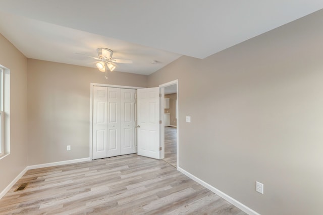 unfurnished bedroom featuring light hardwood / wood-style floors, a closet, and ceiling fan