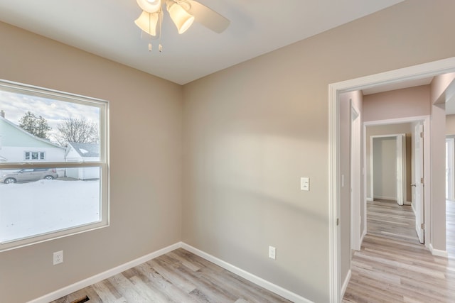 empty room featuring ceiling fan, plenty of natural light, and light hardwood / wood-style floors