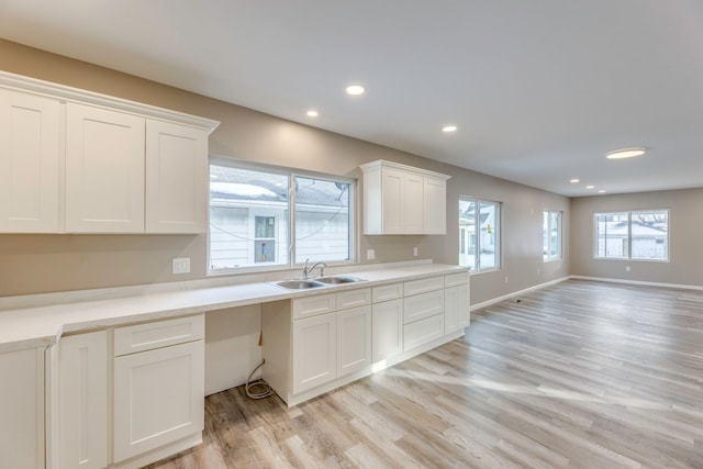 kitchen featuring white cabinetry, light hardwood / wood-style floors, and sink