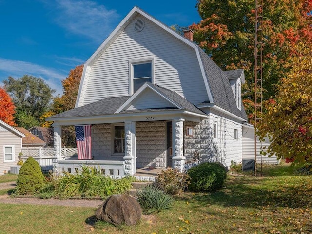 view of front of house featuring a porch, central AC unit, and a front lawn