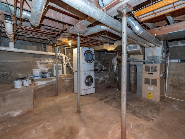 basement featuring stacked washing maching and dryer and heating unit