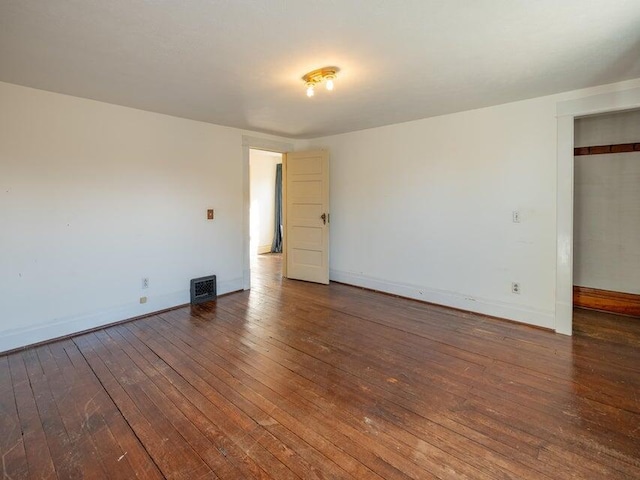 unfurnished room with dark hardwood / wood-style flooring