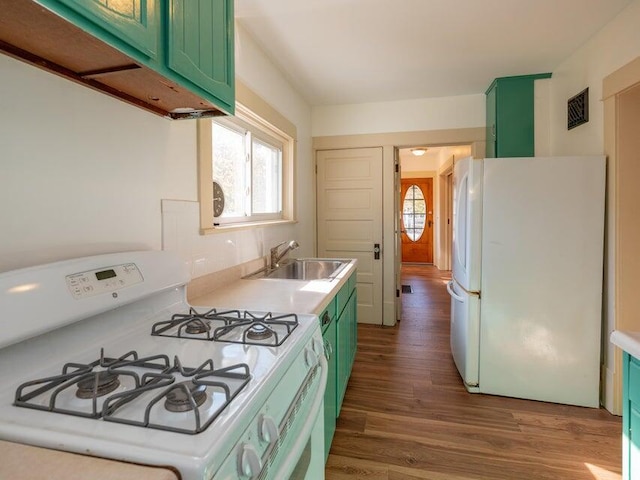 kitchen with sink, white appliances, plenty of natural light, and green cabinetry