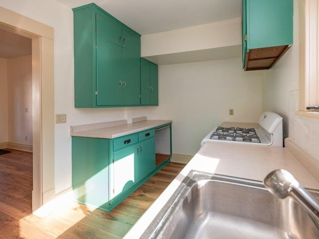 kitchen featuring green cabinets, sink, range, and dark hardwood / wood-style flooring