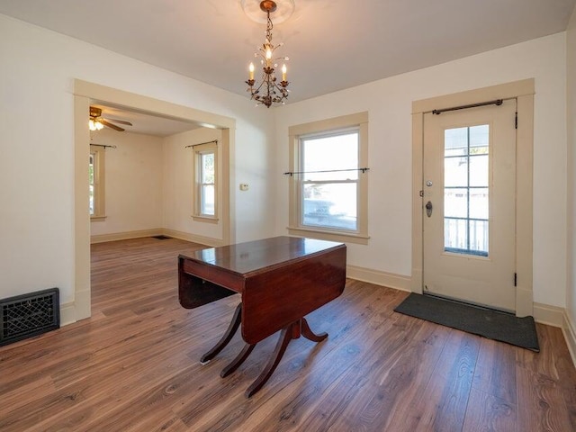 doorway featuring dark wood-type flooring and an inviting chandelier