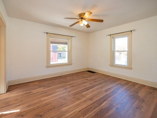 empty room with hardwood / wood-style flooring and ceiling fan