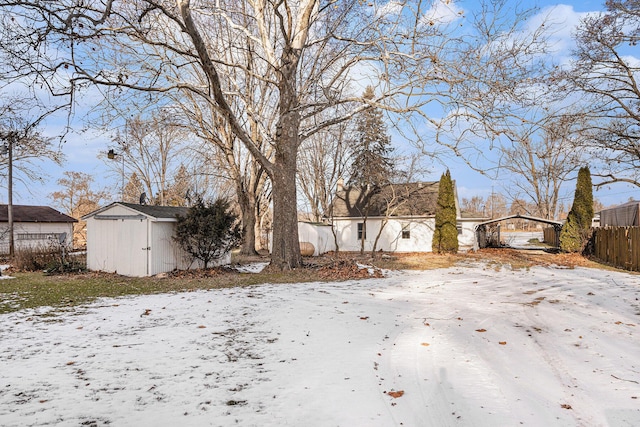 yard covered in snow with a shed