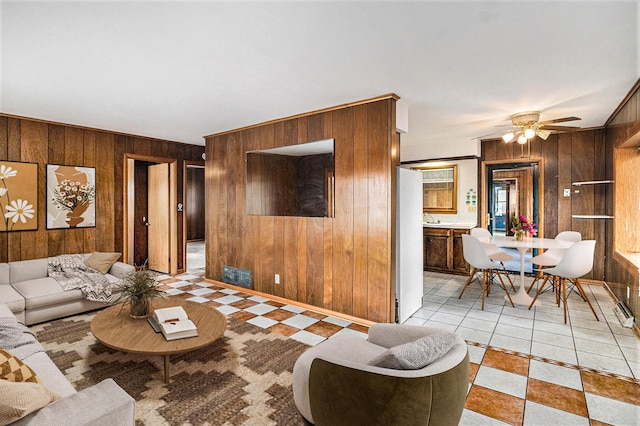 living room with ceiling fan and wooden walls