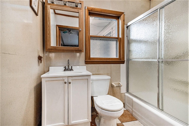 full bathroom featuring toilet, vanity, and bath / shower combo with glass door