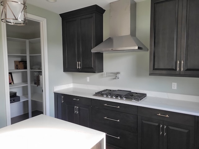 kitchen with stainless steel gas stovetop and wall chimney exhaust hood