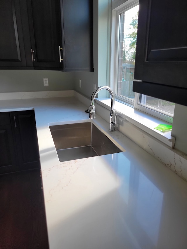 kitchen with light stone counters and sink