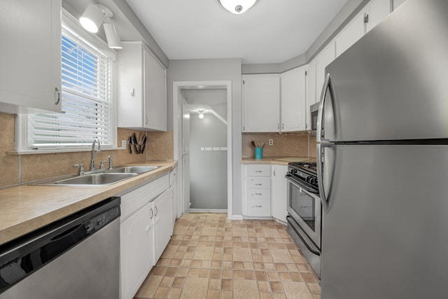 kitchen featuring stainless steel appliances, sink, and white cabinets