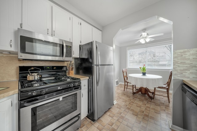 kitchen with white cabinetry, ceiling fan, appliances with stainless steel finishes, and backsplash