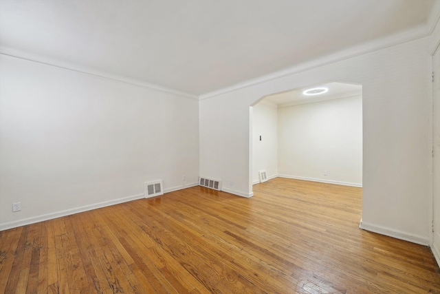 empty room featuring crown molding and hardwood / wood-style floors