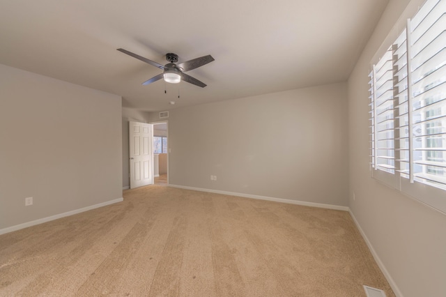 carpeted spare room featuring ceiling fan