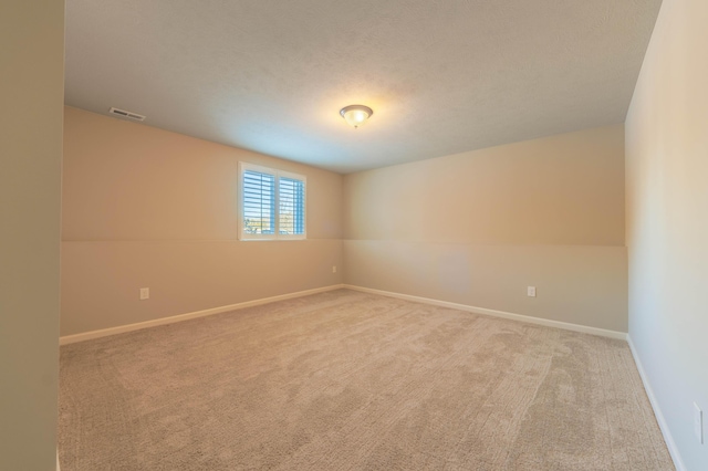 carpeted spare room featuring a textured ceiling