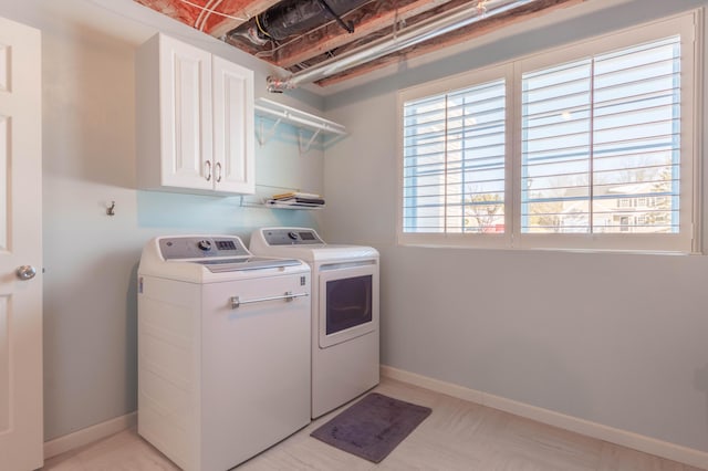 washroom featuring cabinets and washer and clothes dryer