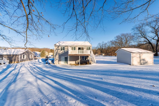 snow covered back of property with a storage unit