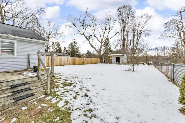 yard layered in snow featuring a shed