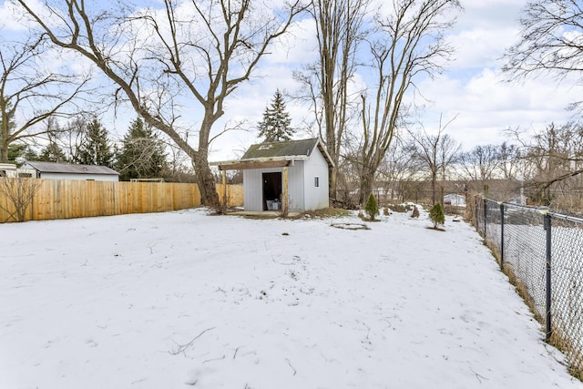 yard layered in snow with a shed