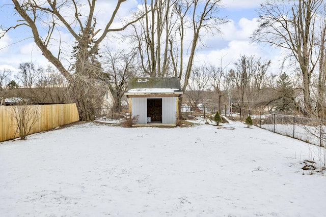 yard layered in snow featuring a storage unit