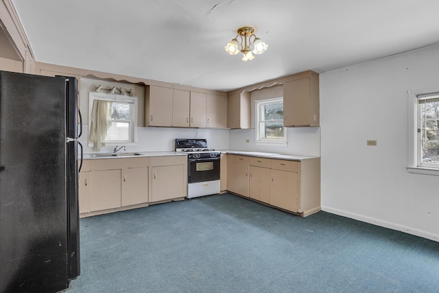 kitchen featuring black fridge, a healthy amount of sunlight, and gas range gas stove