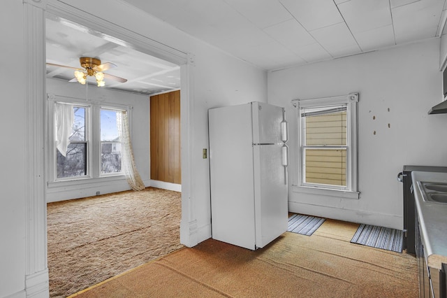 kitchen with white fridge, carpet floors, sink, and ceiling fan