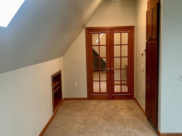 bonus room featuring lofted ceiling, light colored carpet, and french doors