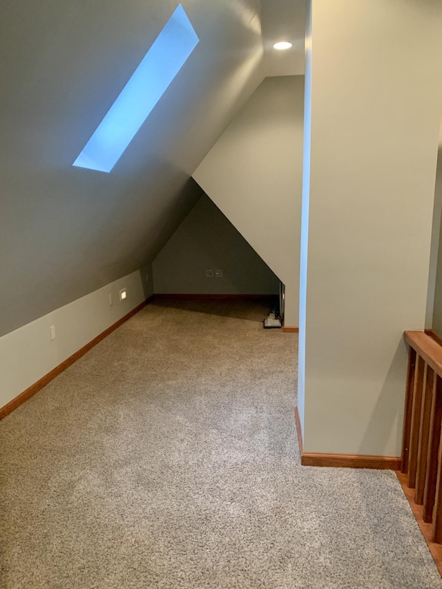 bonus room featuring carpet floors and vaulted ceiling with skylight