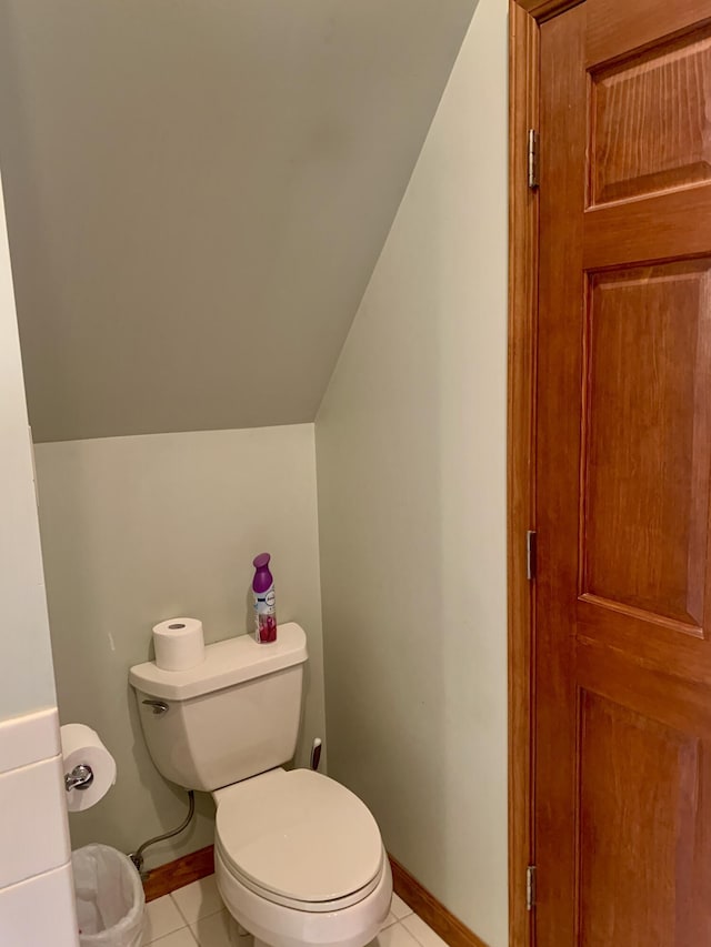 bathroom with tile patterned flooring, vaulted ceiling, and toilet