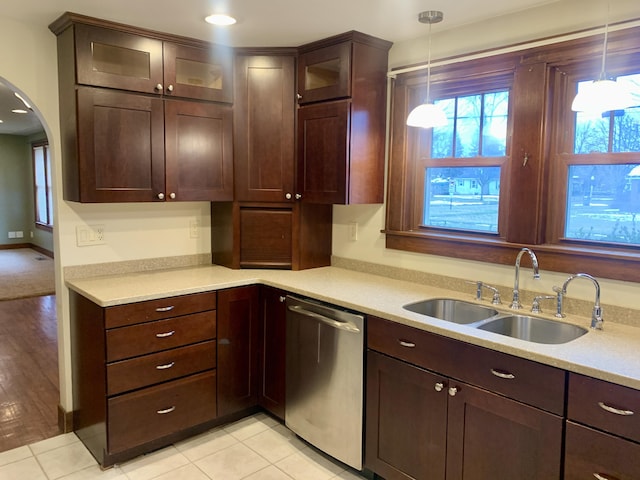 kitchen featuring light tile patterned flooring, sink, decorative light fixtures, dark brown cabinets, and dishwasher