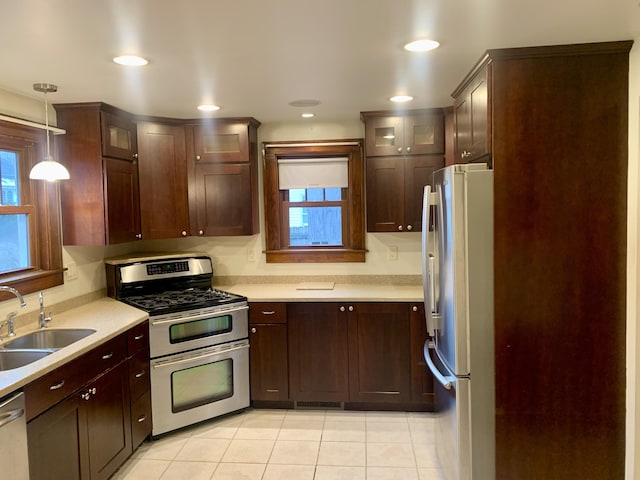 kitchen featuring pendant lighting, sink, light tile patterned floors, and stainless steel appliances