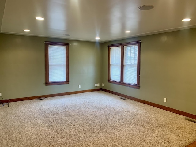 empty room featuring ornamental molding and carpet