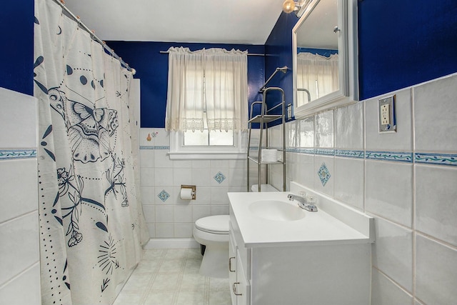 bathroom with a shower with curtain, vanity, toilet, and tile walls